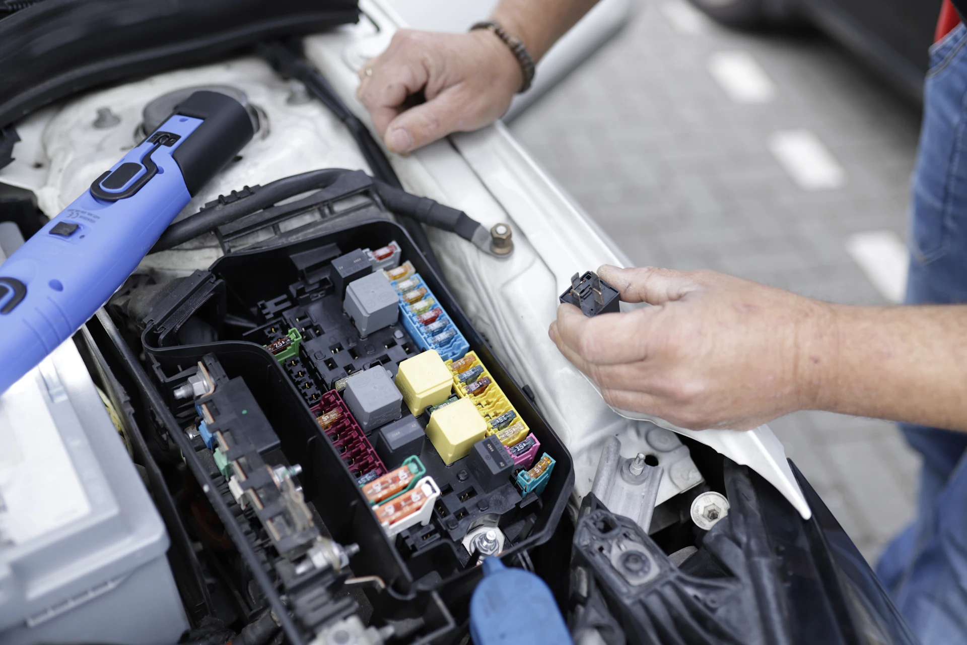 Technician repairing a car fuse box during auto electrical repair in Toronto