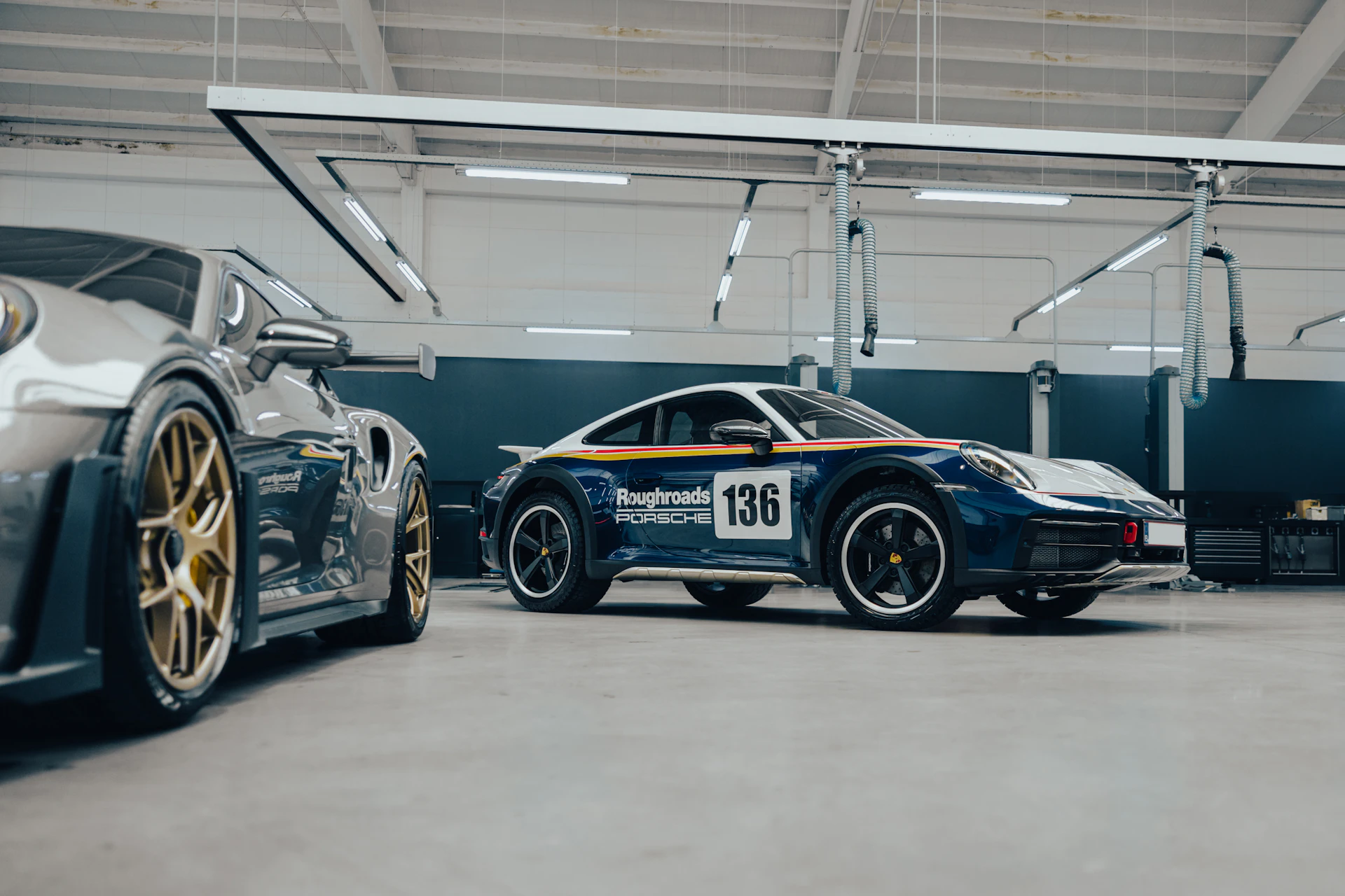 Two Porsche 911 sports cars in a bright Toronto car repair workshop