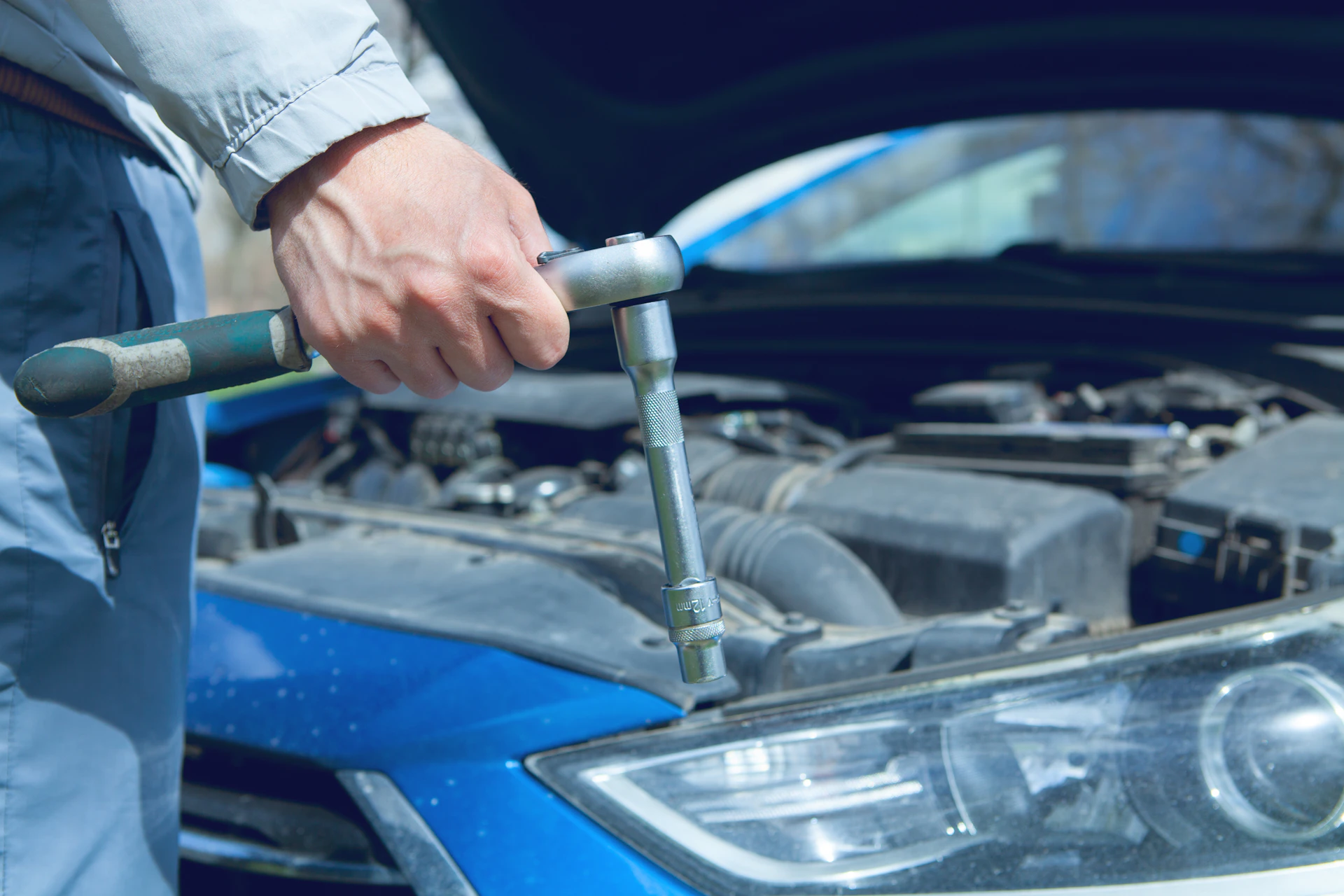 Auto mechanic using a ratchet in an engine bay during car repair in Toronto