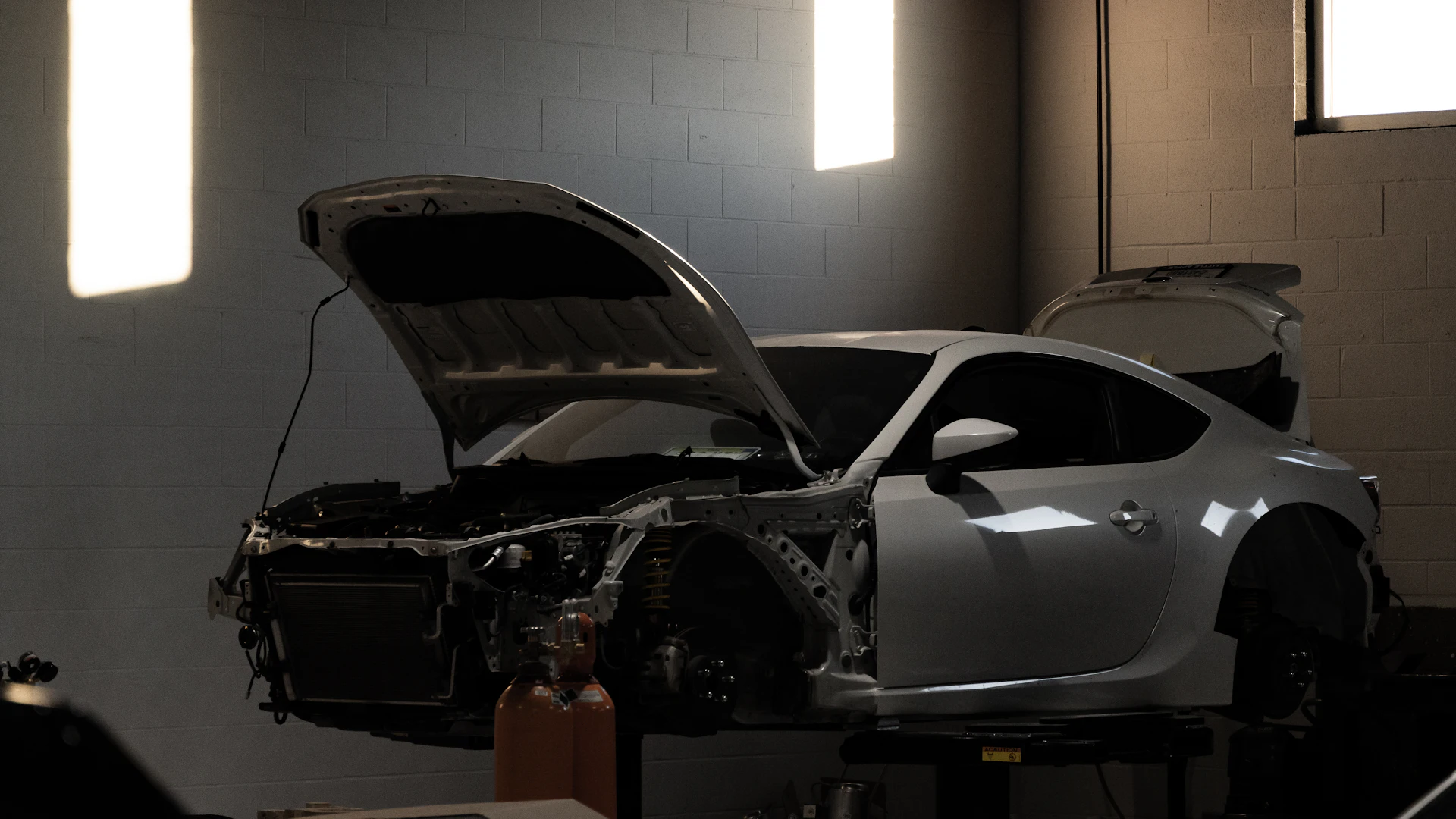 Sports car front structure disassembled for vehicle structural repair in Toronto